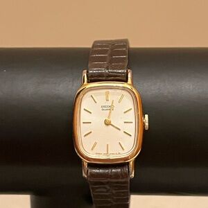 vintage Seiko women's gold-tone quartz watch with a white dial/brown strap